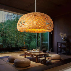 Woven pendant light hanging in a modern living room with a view of trees outside.